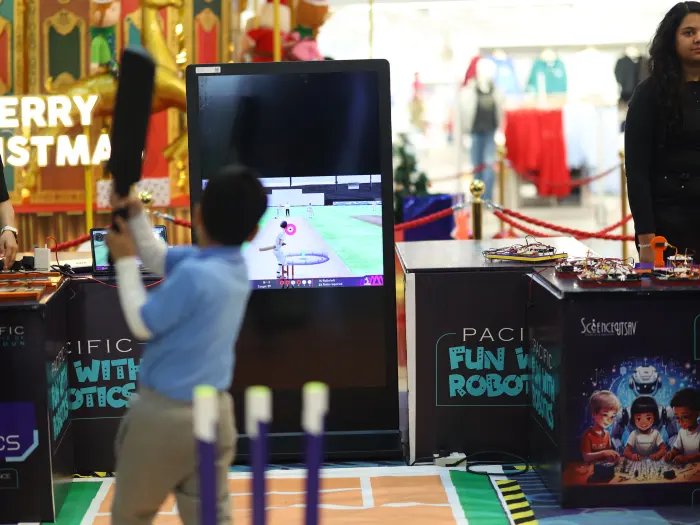 A boy playing a motion-controlled cricket game at a co-branded MakerMasti brand activation stand in Pacific Mall