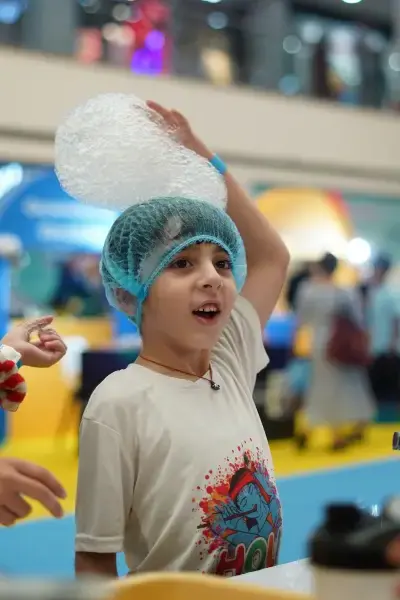 A child producing a long rope of foam bubbles from a bottle